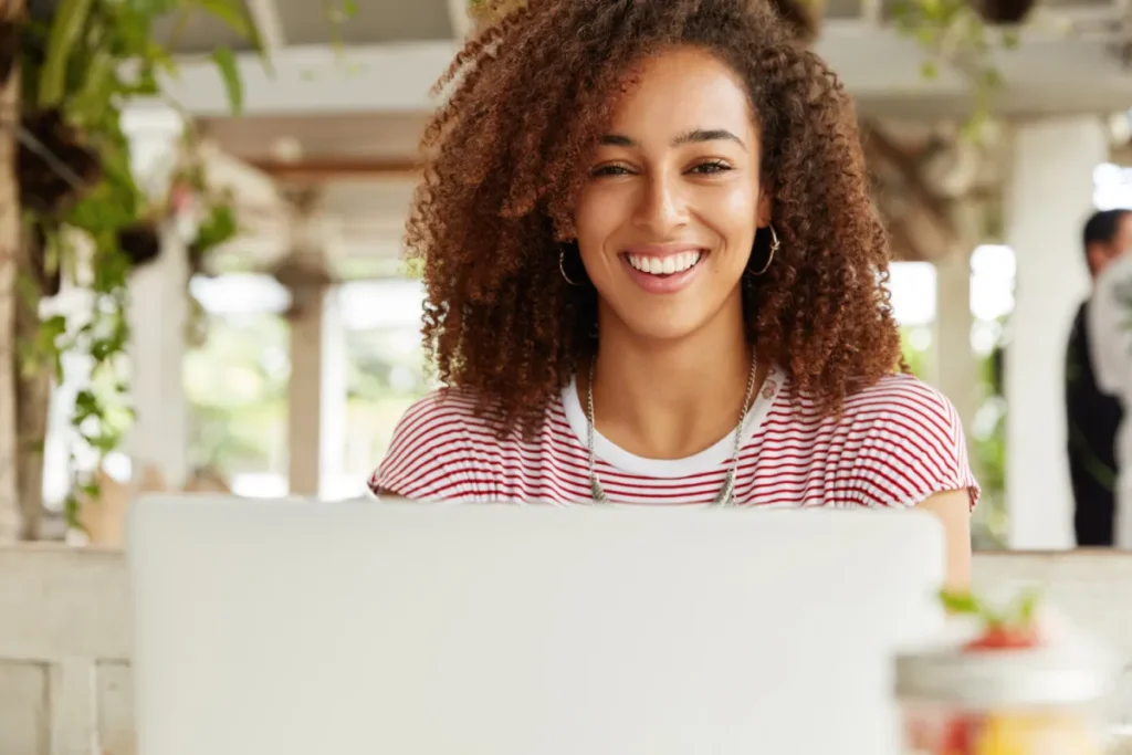 girl at cafe reading and smiling on the computer at the email design