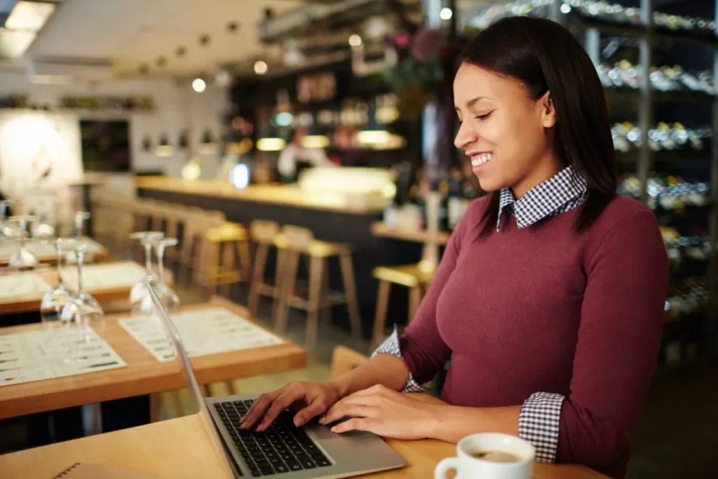 Woman in her bakery, looking at her computer getting ready to send out some test emails for her next email marketing campaign