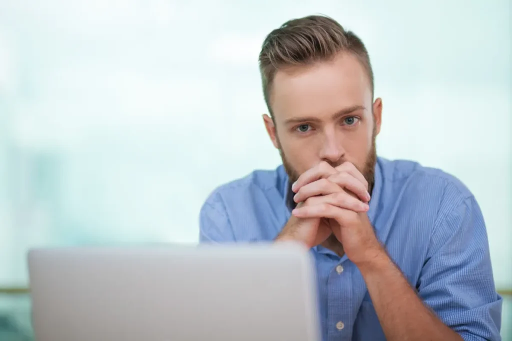 Man sitting at computer looking frustrated because his email marketing campaign is not working out. He made some mistakes.