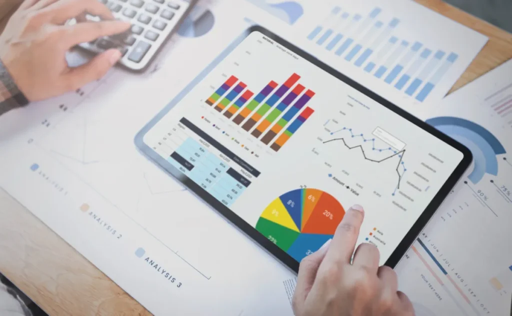 Email marketer, looking at iPad on top of graphs showcasing how you can measure performance and email marketing