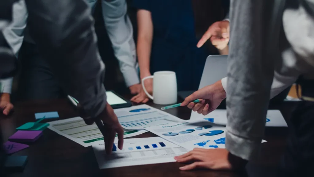 A team gathering around a table to set goals as a marketing team