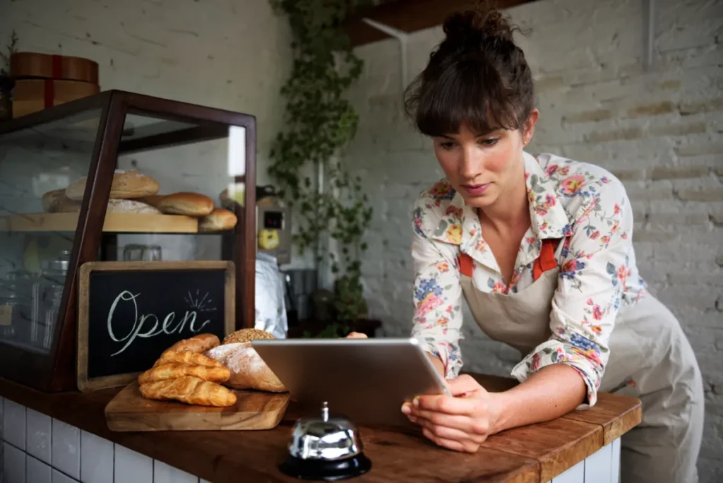 woman tracking the performance of her marketing campaign at her work leaning over table