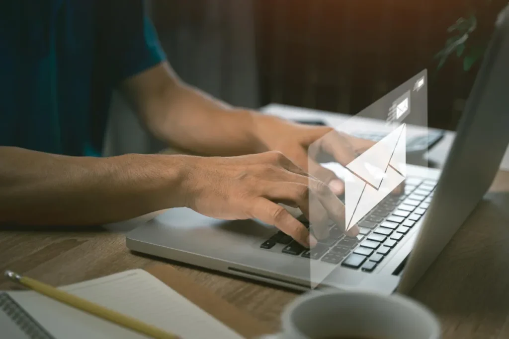 person typing an email with an email graphic over hands