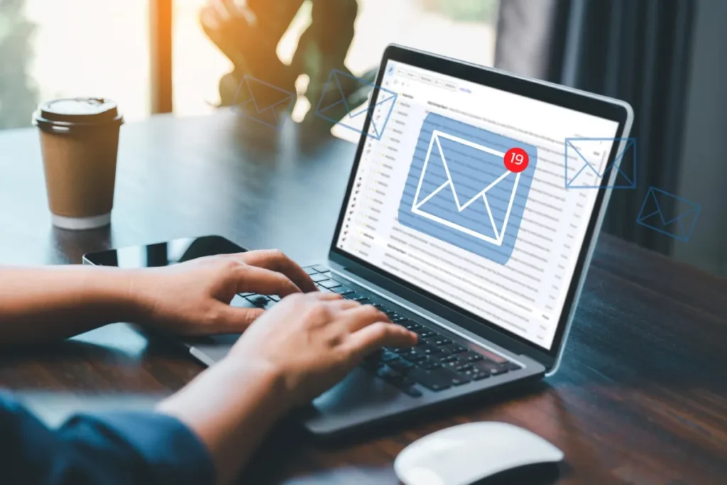 A woman on the computer with an email graphic on the screen her hands are on the keyboard and she's typing